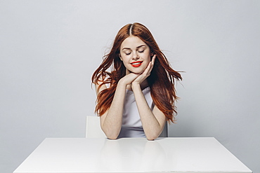 Pensive Caucasian woman sitting at windy table