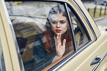 Pensive Caucasian woman in back seat of car leaning on window