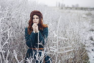 Caucasian woman rubbing hands in winter field