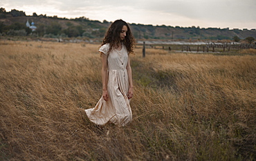 Serious Caucasian woman walking in field