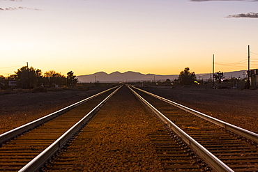 Railroad tracks in mountain landscape at sunset