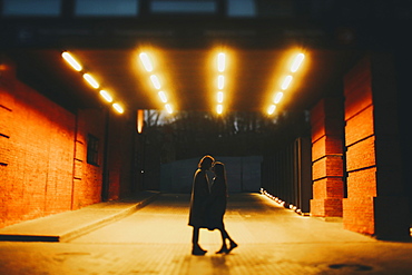 Caucasian couple standing on street in tunnel