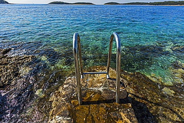 Metal railing on rocks at ocean