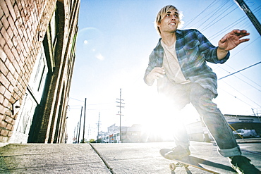 Caucasian man skateboarding on urban sidewalk