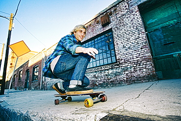 Caucasian man skateboarding on urban sidewalk