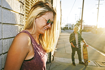 Caucasian woman laughing on sidewalk