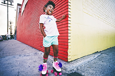 Black girl wearing roller skates on urban sidewalk