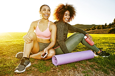 Smiling women sitting in sunny field