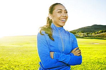 Mixed Race woman laughing in sunny field