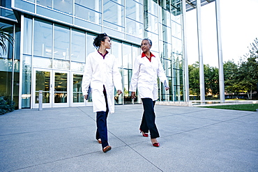 Doctors walking and talking outdoors at hospital