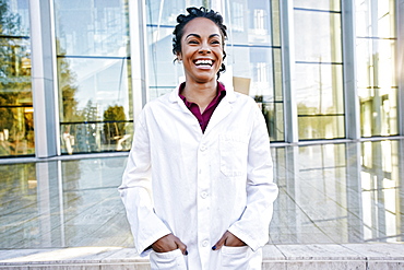 Portrait of laughing Mixed Race doctor outdoors at hospital