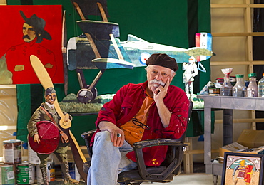 Portrait of older Caucasian man sitting in workshop