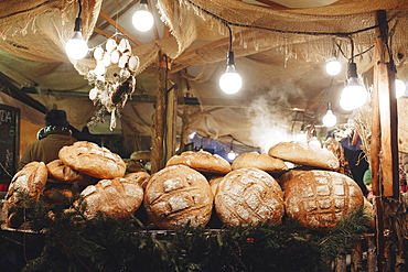 Pile of loaves of bread on table in tent