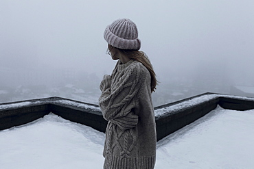 Caucasian woman standing on rooftop in winter