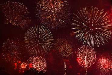 Fireworks exploding in red sky