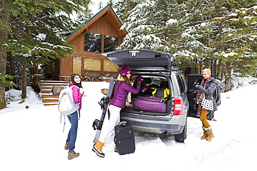 Friends unloading car at winter resort