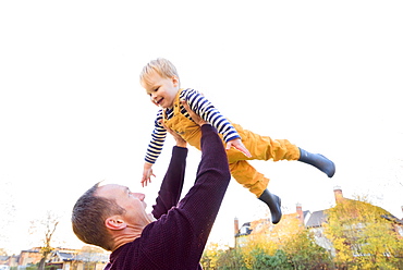 Caucasian father lifting son