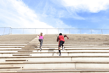 Man and woman running on bleachers