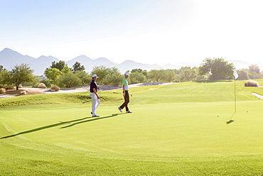 Friends walking on golf course