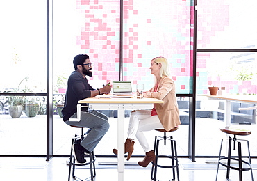 Creative business people talking at table with laptop