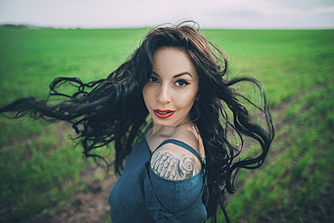 Caucasian woman tossing hair in field