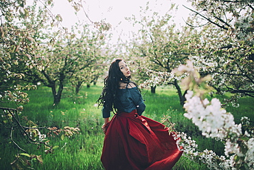 Caucasian woman walking near flowering trees