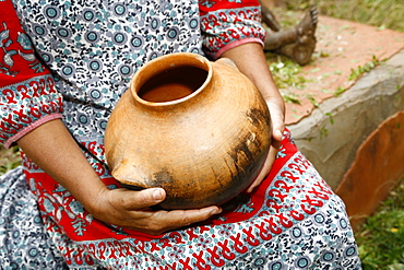 Woman sitting and holding clay pot