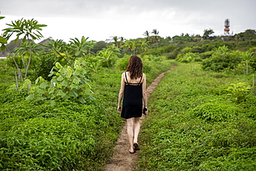 Woman walking on path through foliage