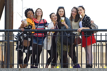 Portrait of smiling women posing behind railing