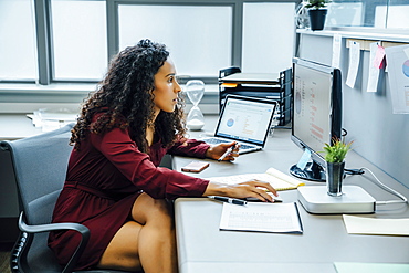 Mixed race businesswoman using computer in office