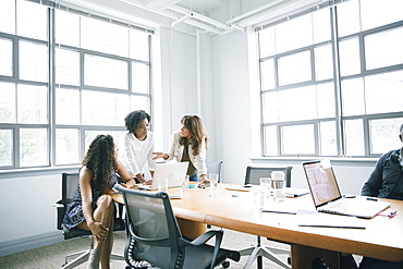 Businesswomen using laptop in meeting