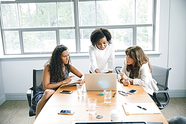 Businesswomen using laptop in meeting