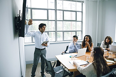 Businessman talking near visual screen in meeting