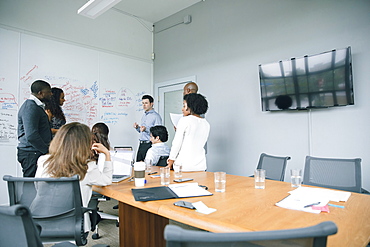 Businessman talking near whiteboard in meeting