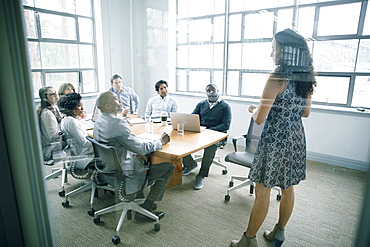 Businesswoman talking behind window in meeting