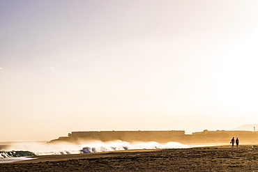 Distant people walking on beach