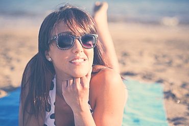 Caucasian woman laying on beach blanket