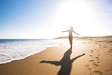 Carefree Caucasian woman walking on beach