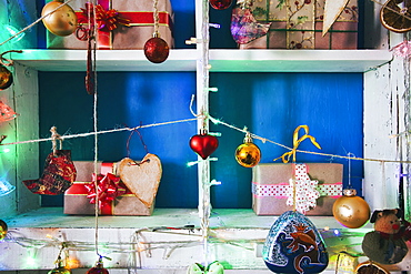 Gift boxes on wooden shelves near ornaments