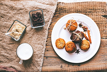 Bundles of cookies tied with string on plate near ingredients