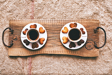 Coffee and heart-shape cookies on wooden tray