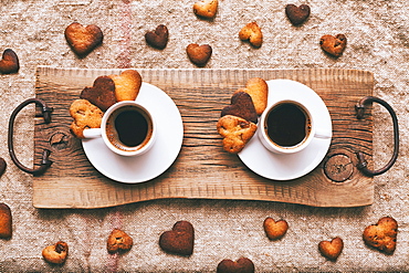 Coffee and heart-shape cookies on wooden tray