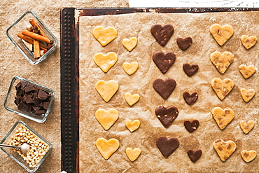 Heart-shape cookies on baking sheet near ingredients