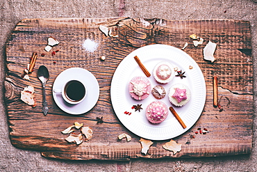 Cupcakes on ingredients on wooden tray with coffee