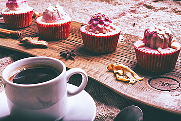 Cupcakes on ingredients on wooden tray with coffee