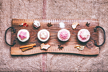 Cupcakes on ingredients on wooden tray