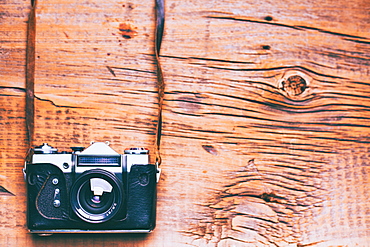 Camera and strap on wooden table