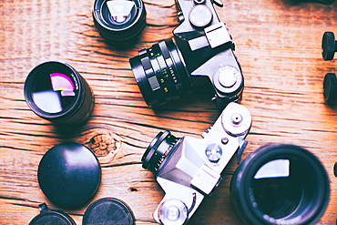 Cameras and lenses on wooden table