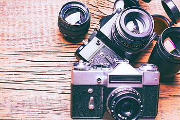 Cameras and lenses on wooden table