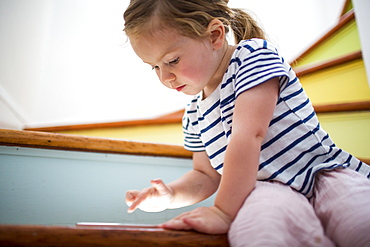 Caucasian girl using digital tablet on staircase